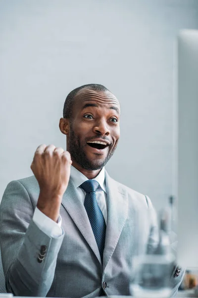 Ritratto di eccitato uomo d'affari afro-americano sul posto di lavoro in ufficio — Stock Photo