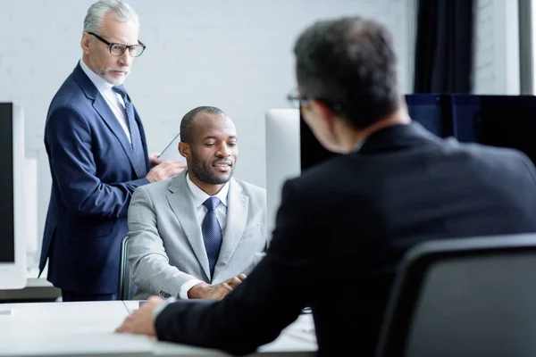 Vista parziale di imprenditori multiculturali che lavorano insieme in ufficio — Foto stock