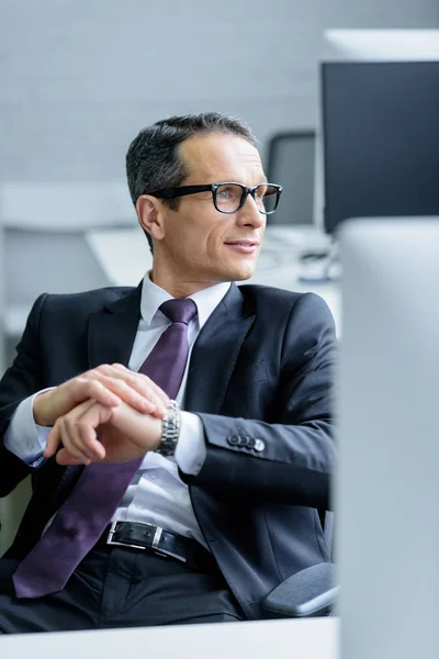 Retrato de hombre de negocios en gafas mirando hacia otro lado en la oficina - foto de stock