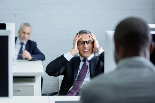 Selektiver Fokus gestresster Geschäftsleute am Arbeitsplatz im Büro — Stockfoto