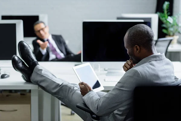 Foco seletivo do empresário afro-americano usando tablet no local de trabalho no escritório — Fotografia de Stock