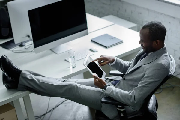 Souriant homme d'affaires afro-américain en utilisant une tablette sur le lieu de travail dans le bureau — Photo de stock