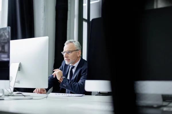 Selective focus of senior businessman working on computer in office — Stock Photo