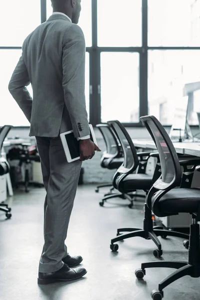 Teilbild eines afrikanisch-amerikanischen Geschäftsmannes mit Tablet in der Hand im Büro — Stockfoto