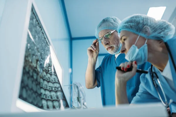 Вид снизу доктора, смотрящего на рентген пациента — стоковое фото
