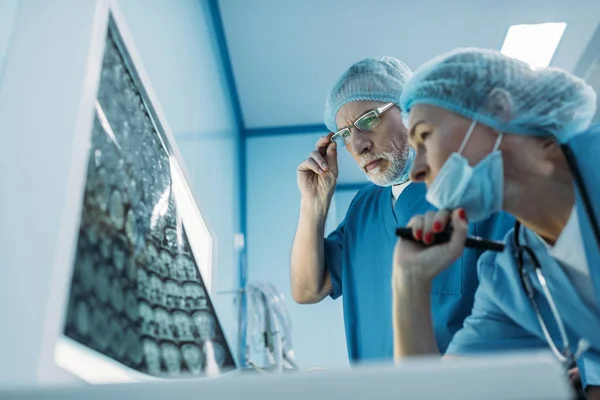 Visão inferior dos médicos que olham para a radiografia do paciente — Fotografia de Stock