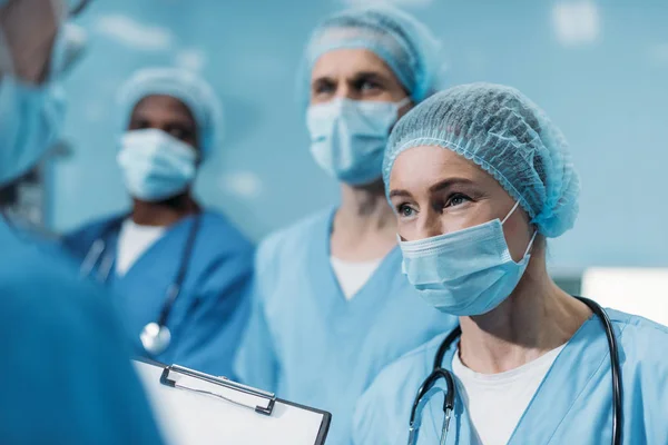 Multicultural surgeons looking away in operating room — Stock Photo