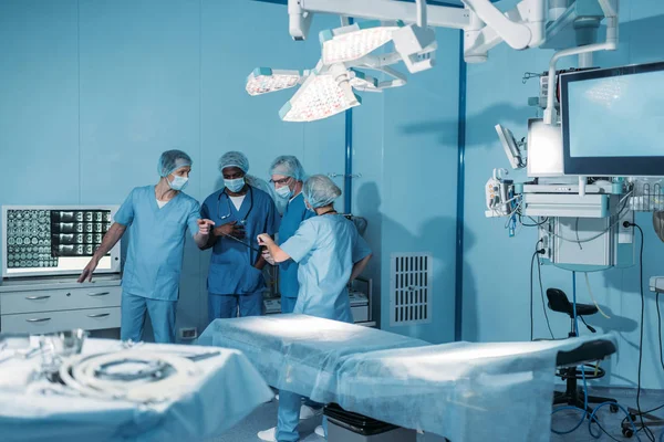 Four multicultural surgeons in operating room — Stock Photo