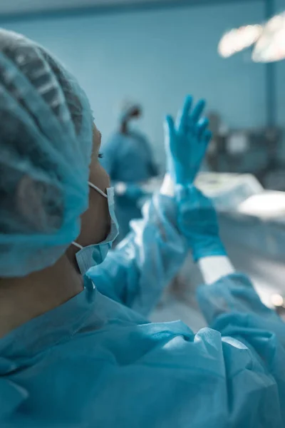 Cropped image of doctor wearing medical gloves — Stock Photo