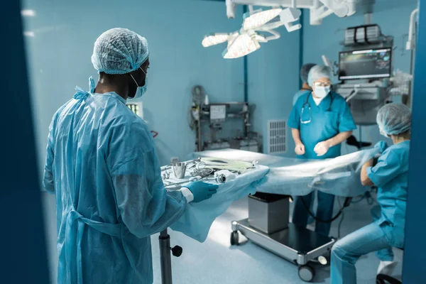 Африканский американский врач держит поднос с медицинскими инструментами для хирургии — стоковое фото