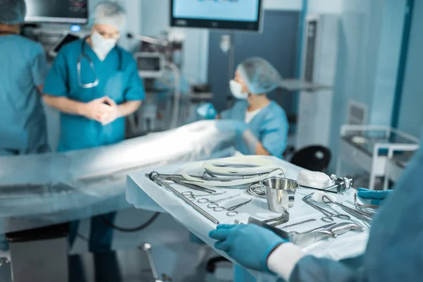 Cropped image of doctor holding tray with medical tools for surgery — Stock Photo