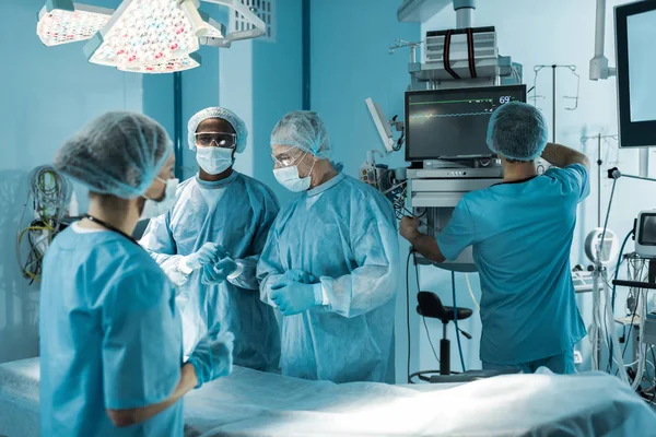 Four multicultural doctors preparing for surgery — Stock Photo