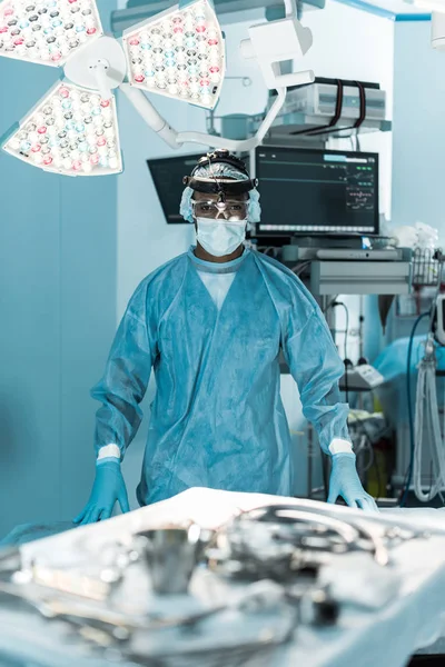 Афроамериканський хірург дивиться на камеру в операційній кімнаті — стокове фото