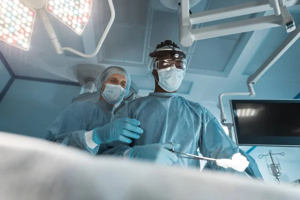 Vue du bas des chirurgiens multiculturels en chirurgie — Photo de stock