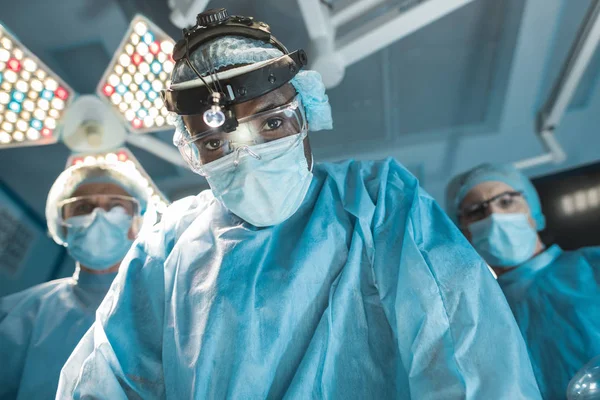 Вид снизу на африканского американского хирурга, смотрящего в камеру — стоковое фото