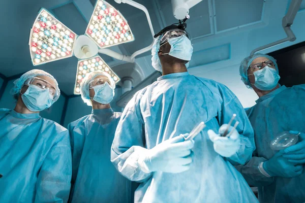 Вид снизу мультикультурных хирургов, отворачивающихся — стоковое фото
