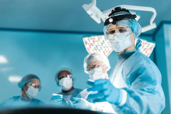 Quatre médecins multiethniques en salle d'opération — Photo de stock