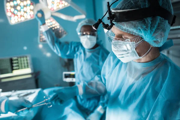 Geschnittenes Bild einer Krankenschwester, die dem Chirurgen im Operationssaal eine medizinische Schere reicht — Stockfoto