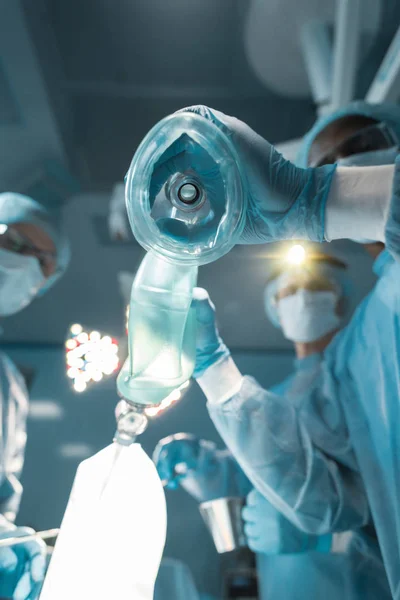 Bottom view of african american anesthetist holding oxygen mask — Stock Photo