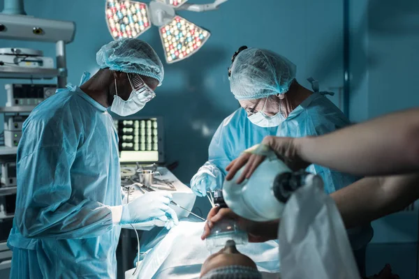 Cirurgiões multiétnicos e pacientes em centro cirúrgico — Fotografia de Stock