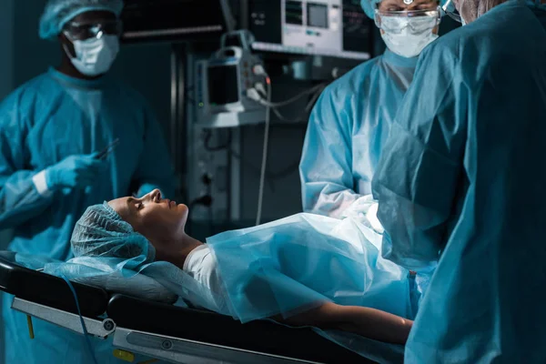 Multiethnic surgeons and patient in operating room — Stock Photo