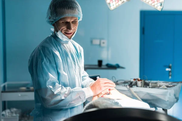 Усміхнений лікар і пацієнт тримає руки в операційній — стокове фото