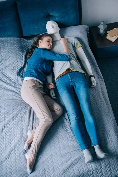 Young woman lying in bed with mannequin, perfect relationship dream concept — Stock Photo