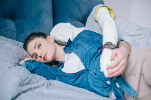 Femme coûteuse couchée sur le lit avec mannequin derrière, concept d'amour à sens unique — Photo de stock