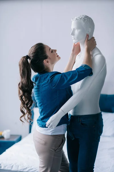 Visão lateral de alegre jovem mulher abraçando manequim, conceito de sonho de relacionamento perfeito — Fotografia de Stock