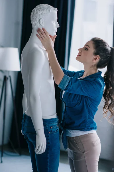 Side view of young woman and mannequin at home, one way love concept — Stock Photo