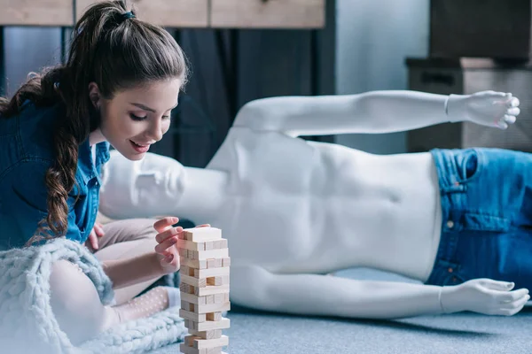 Mujer jugando bloques juego de madera con muñeca laico cerca de casa, concepto de sueño relación perfecta - foto de stock