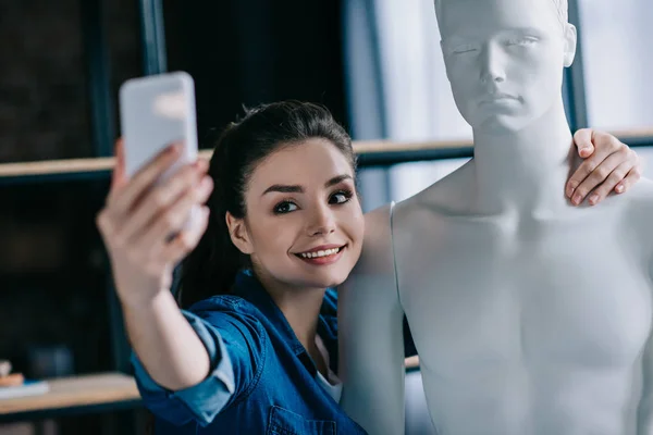 Messa a fuoco selettiva di donna sorridente prendendo selfie insieme con manichino, concetto perfetto rapporto sogno — Foto stock