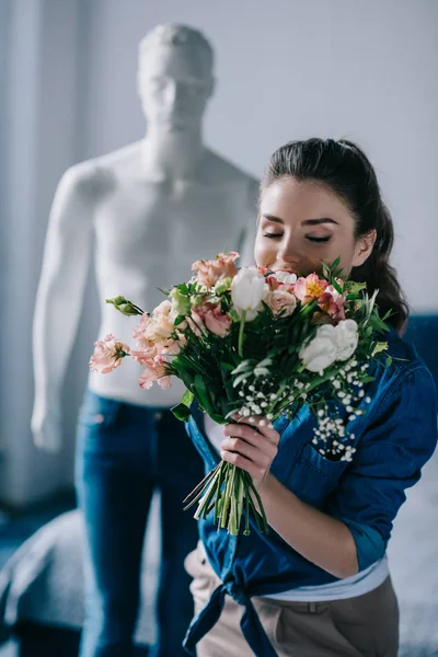 Selective focus of young woman with bouquet of flowers and mannequin behind, one way love concept — Stock Photo