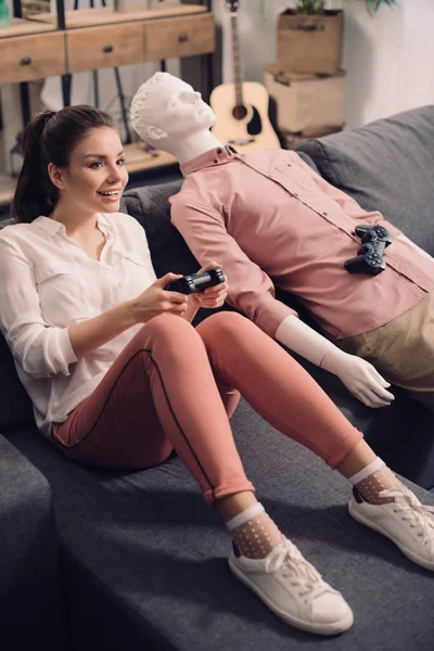 Woman with manikin near by playing video game at home, loneliness concept — Stock Photo