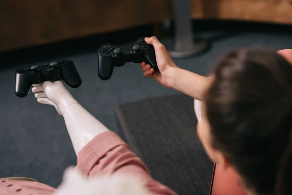 Partial view of woman with manikin near by playing video game at home, loneliness concept — Stock Photo