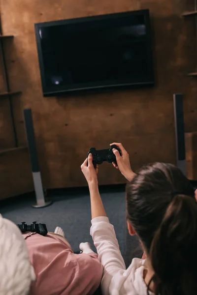 Rückansicht einer Frau mit Schaufensterpuppe in der Nähe von Videospielen zu Hause, Konzept der Einsamkeit — Stockfoto