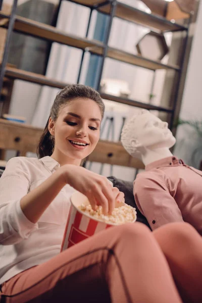 Giovane donna che mangia popcorn con manichino vicino, concetto di amore a senso unico — Foto stock