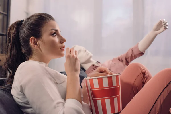 Woman eating popcorn while watching film together with manikin at home, perfect relationship dream concept — Stock Photo