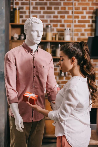 Young woman pretending to except gift from mannikin, loneliness and perfect man dream concept — Stock Photo