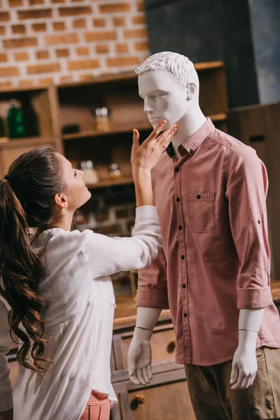 Vue latérale de femme touchant mannequin en vêtements décontractés, concept d'amour à sens unique — Photo de stock