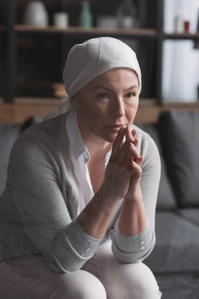 Upset sick mature woman in kerchief sitting and looking away, cancer concept — Stock Photo