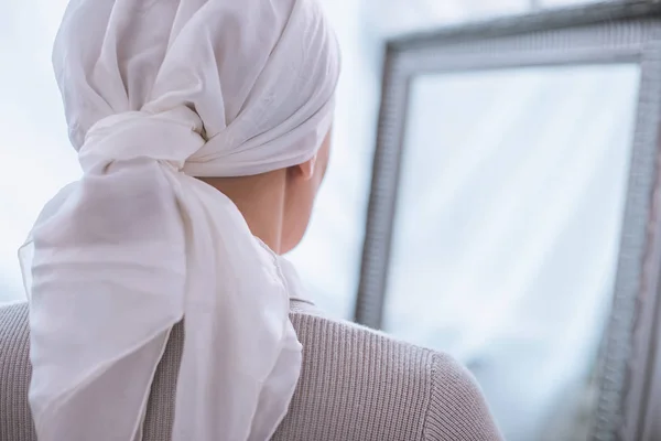 Visão traseira da mulher doente em kerchief pé perto do espelho, conceito de câncer — Fotografia de Stock