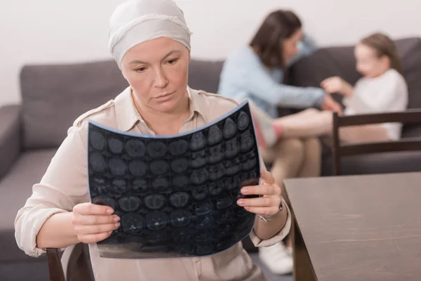 Enferma mujer madura en pañuelo mirando mri scan - foto de stock