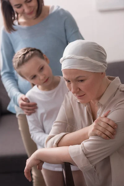 Famiglia sostegno donna malata matura in fazzoletto — Foto stock