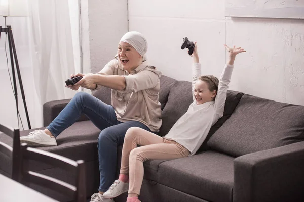 Fröhliche Oma und Enkelin spielen mit Steuerknüppeln, Krebskonzept — Stockfoto