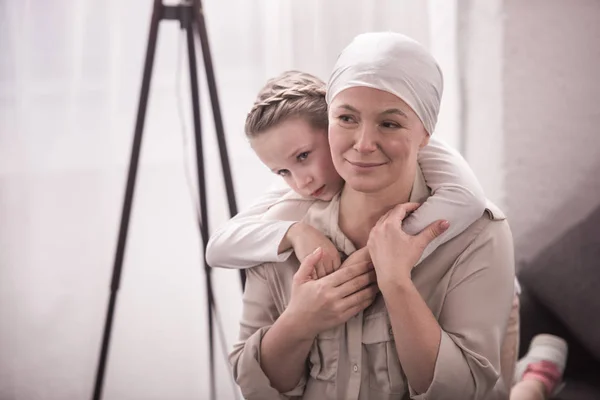 Lindo niño pequeño abrazando abuela enferma en el pañuelo - foto de stock