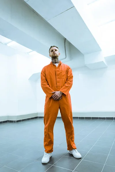 Bottom view of tattooed prisoner standing in prison cell — Stock Photo