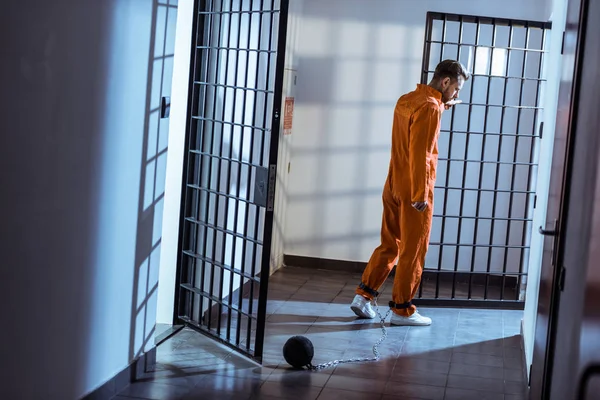 Prisoner walking in corridor with weight tethered to leg — Stock Photo