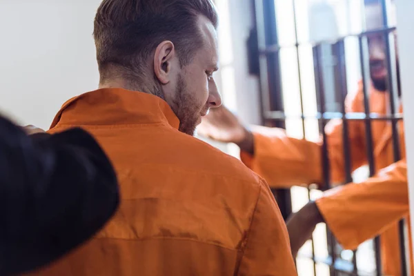 Обрезанный образ тюремного охранника, ведущего преступника — стоковое фото