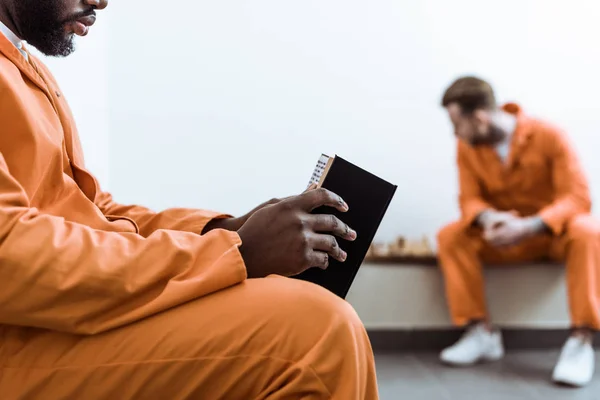 Abgeschnittenes Bild eines afrikanisch-amerikanischen Gefangenen beim Lesen von Buch — Stockfoto